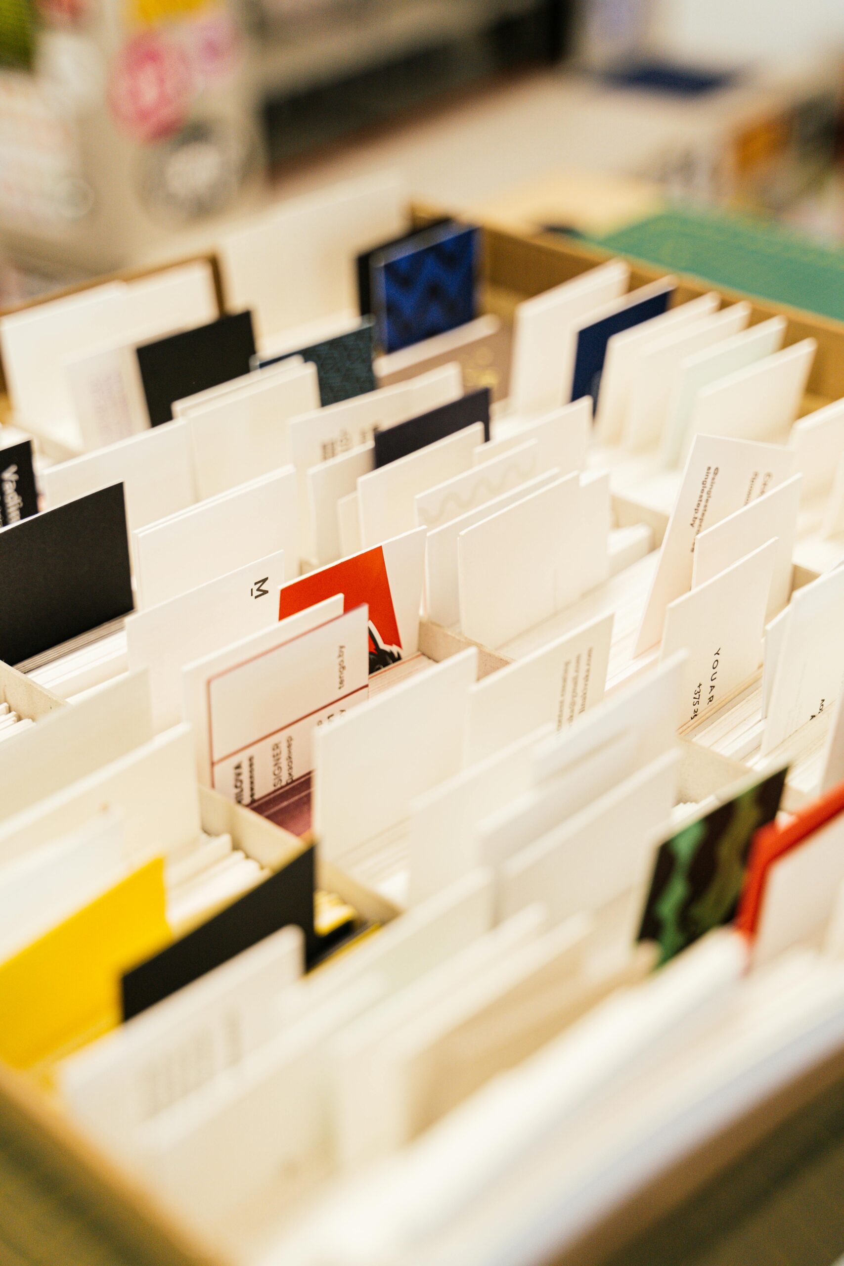 Close-up of assorted business cards neatly organized in a box. Ideal for design inspiration.